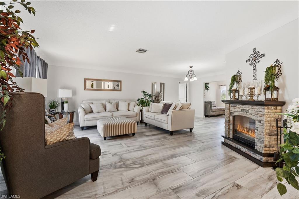 Image 4: Living room featuring a fireplace and suspended lighting