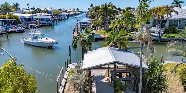 Image 3: View looking south down the canal to the bay. Shared cut-in boat slip and covered bar with metal roof