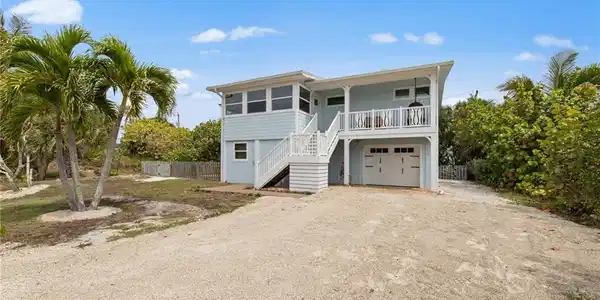 Image 4: Coastal home with driveway and a garage