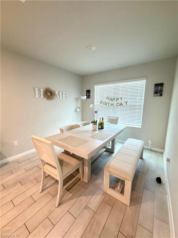 Image 3: Dining room with wood tiled floors and baseboards