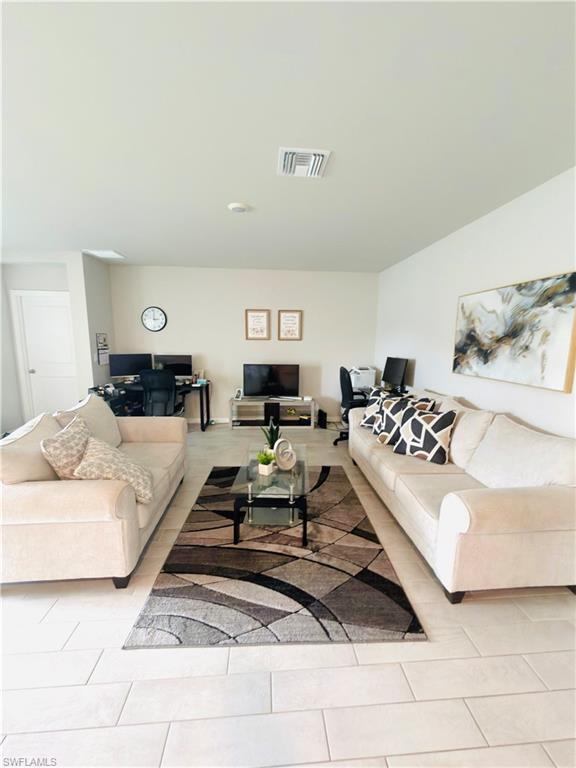 Image 4: Living room with light tile patterned floors