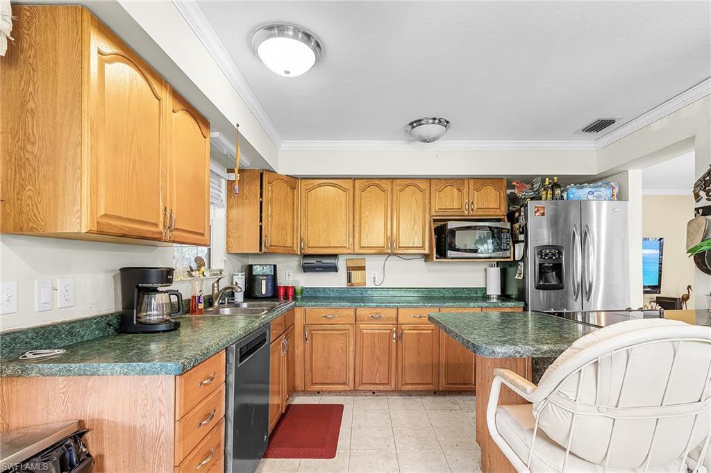 Image 4: Kitchen with stainless appliances and breakfast bar.