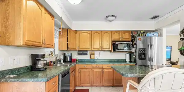 Image 4: Kitchen with stainless appliances and breakfast bar.