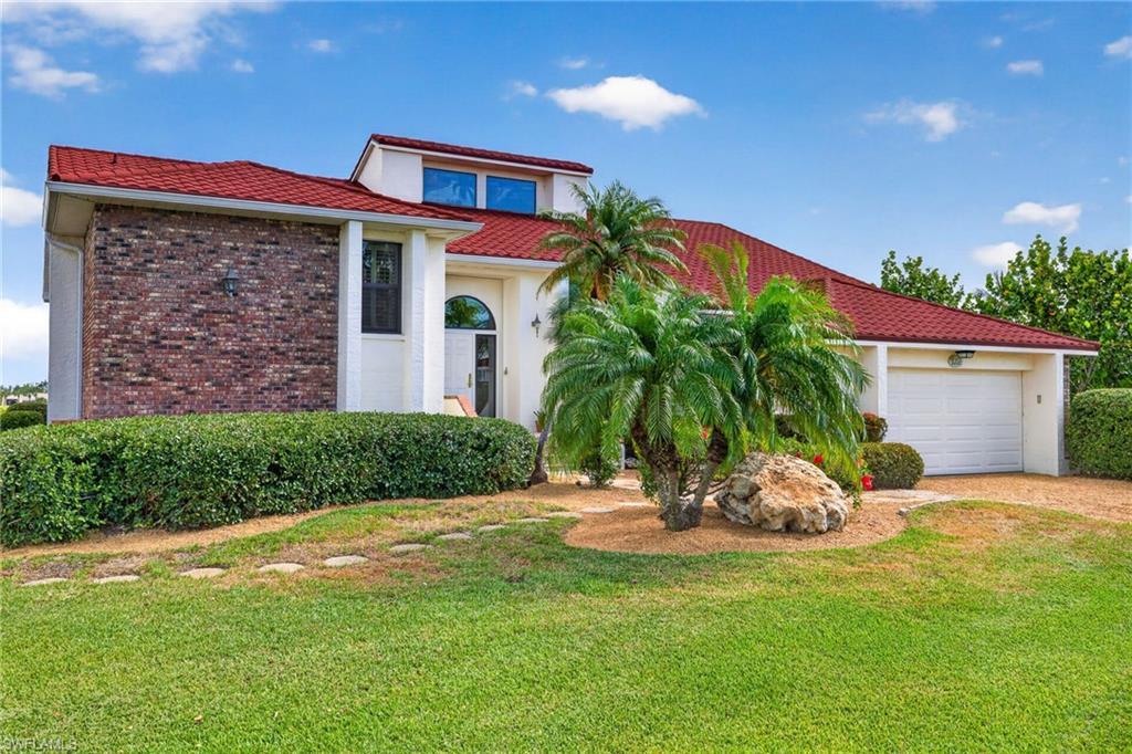 Image 4: Residence featuring a white stucco exterior with a prominent brick facade accent