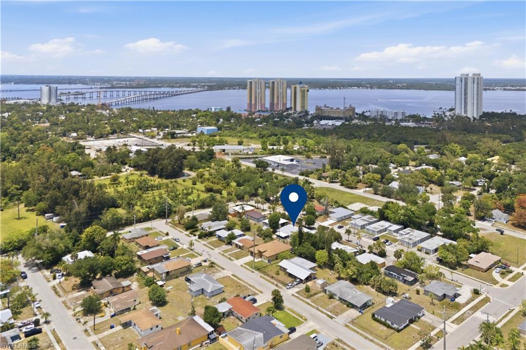 Image 2: Aerial perspective of a residential neighborhood with a prominent water body and distant structures