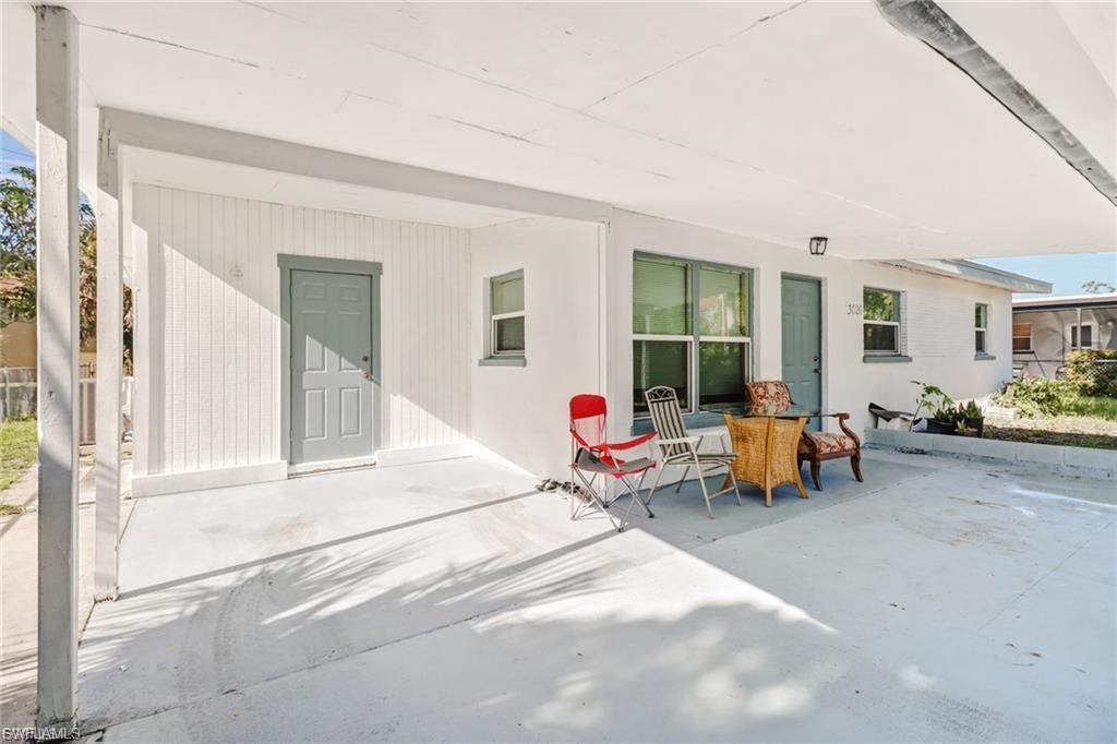 Image 3: Covered carport space with a light gray painted concrete floor