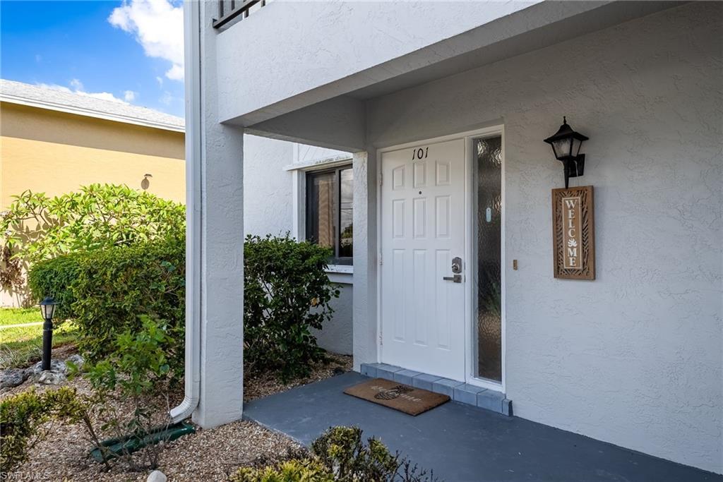 Image 2: Entryway featuring a panel door with sidelight, overhead porch, and exterior wall lantern