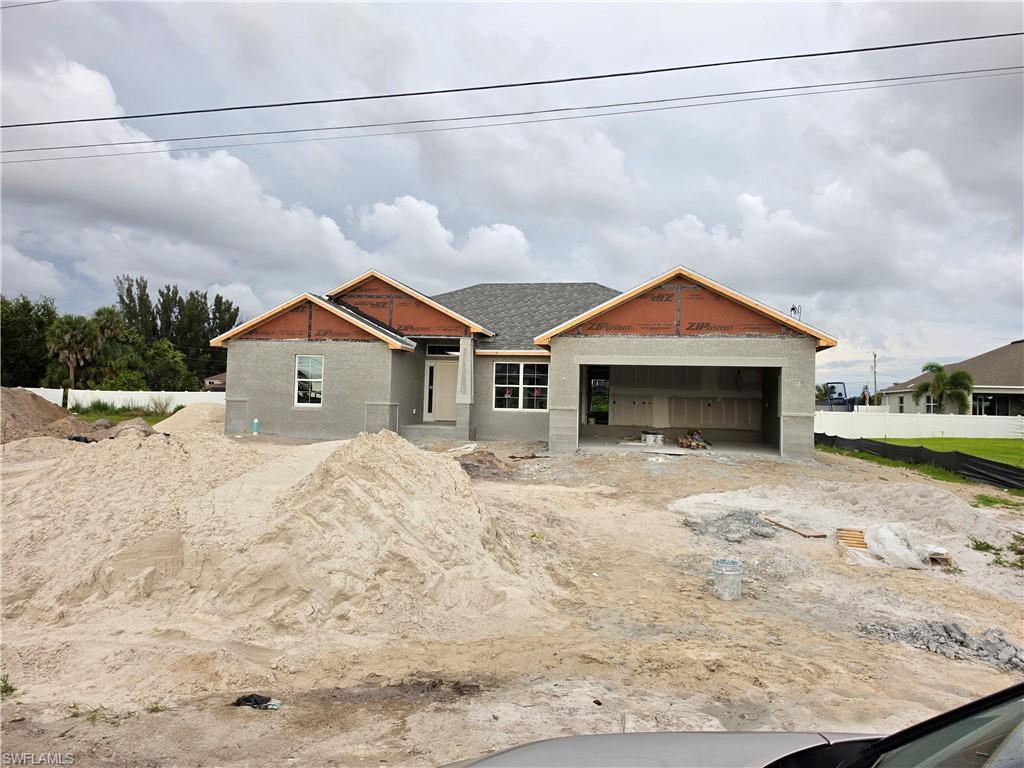 Image 2: Modern single-story residence under construction featuring a grey exterior finish and a dark shingle roof