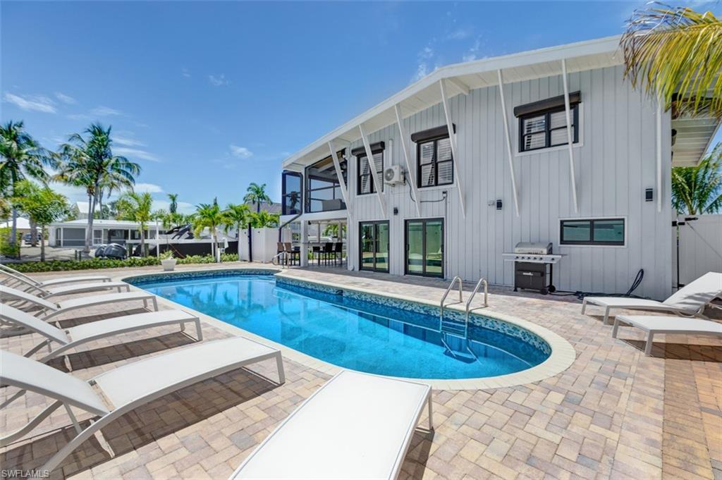 Image 3: Enjoy sunbathing by the expansive pool and deck area