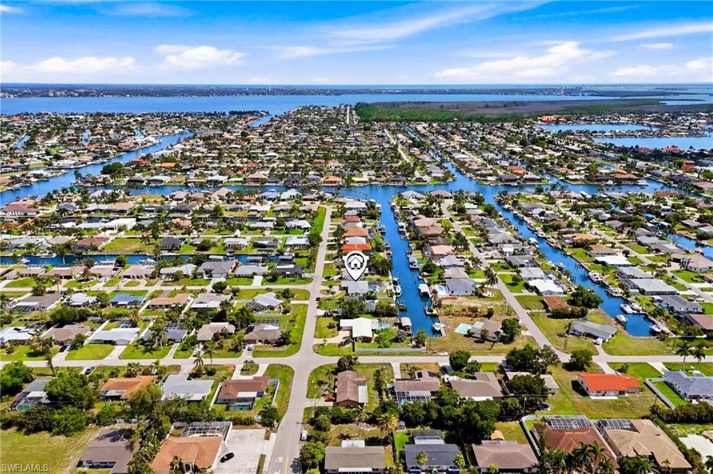 Image 1: An impressive aerial perspective showcasing the home's prime canal-front location, direct Gulf access, and close proximity to some of Southwest Florida's best boating destinations.
