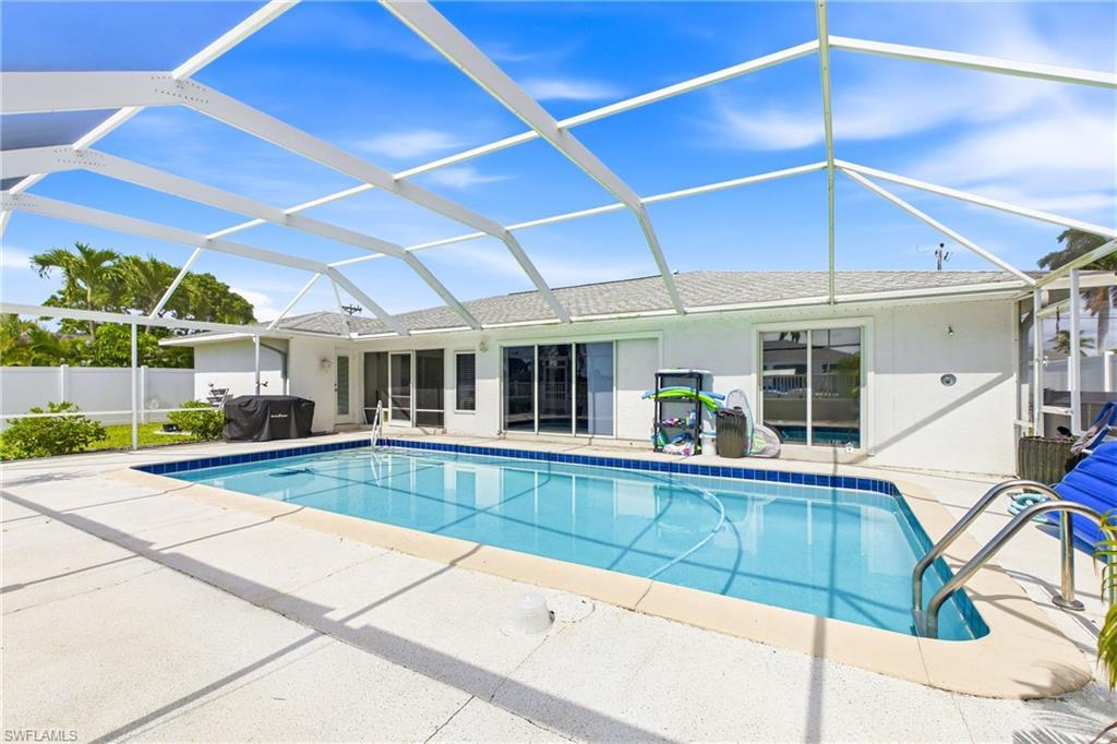Image 4: Your private tropical oasis awaits with a heated pool and expansive outdoor living area.