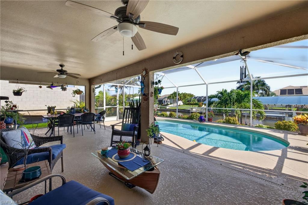 Image 3: Screened lanai featuring a swimming pool, textured concrete deck, and ceiling fans