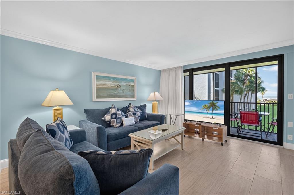 Image 3: Living space featuring light blue wall tones, crown molding, and tiled flooring