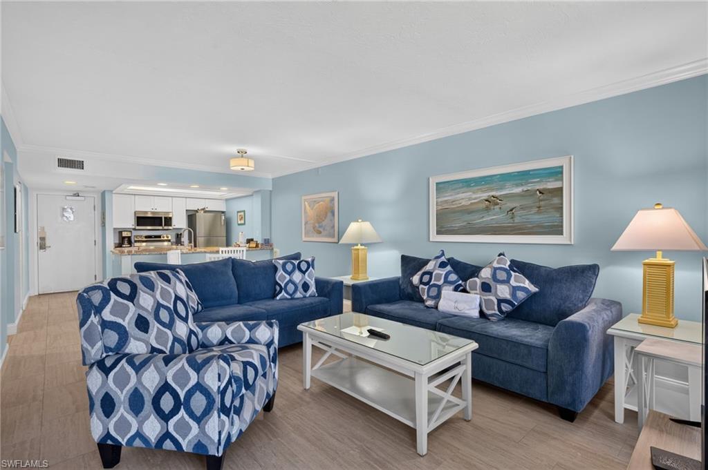 Image 4: Open-concept living area featuring light wood-finish flooring, light blue wall tones, and recessed lighting