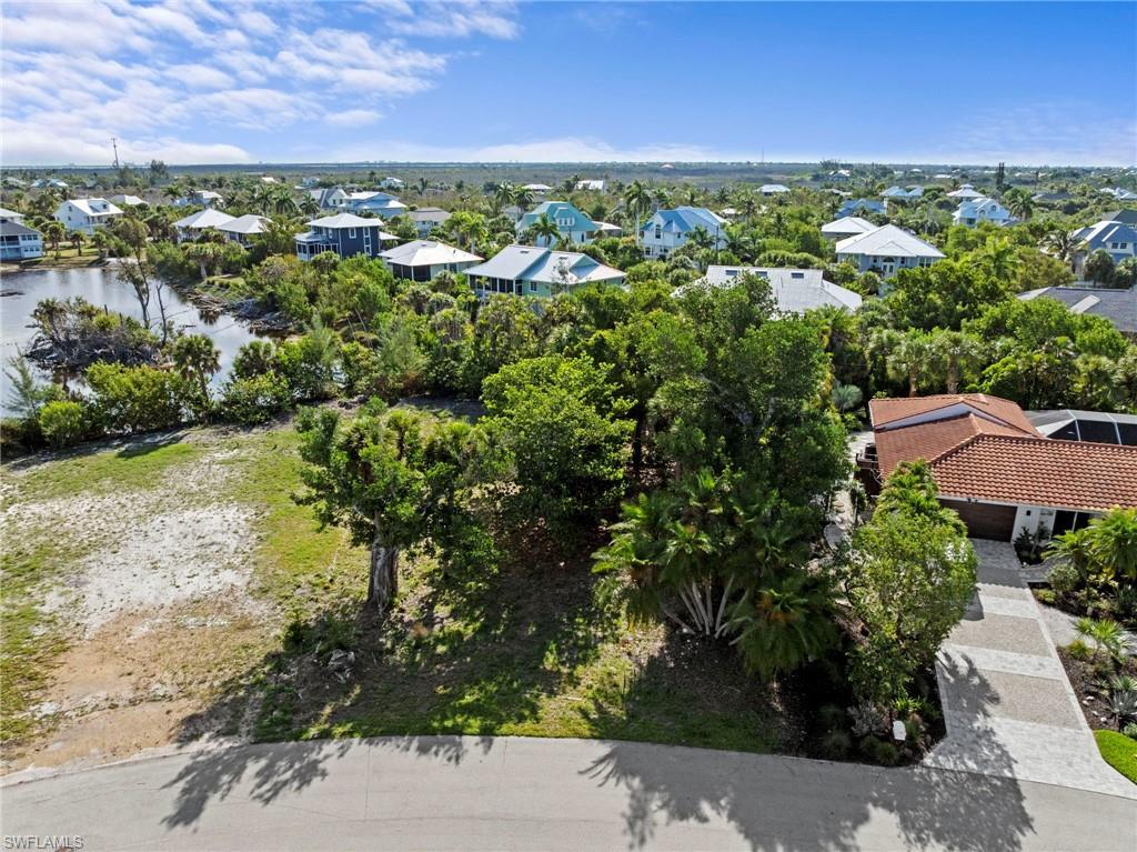 Image 2: Expansive residential lot featuring mature trees and a partial water perimeter