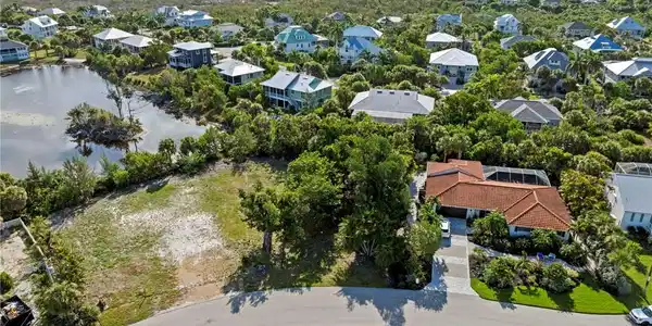 Image 4: Aerial depiction of a residential property featuring a terracotta-tiled roof and a screened-in pool enclosure