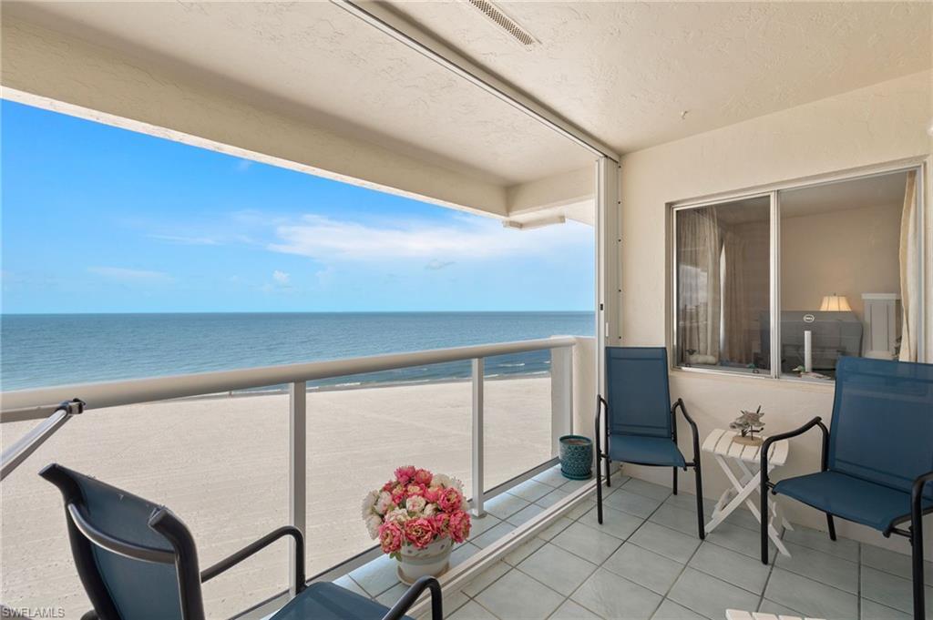 Image 3: Enclosed balcony featuring a tiled floor, glass railings, and expansive ocean frontage
