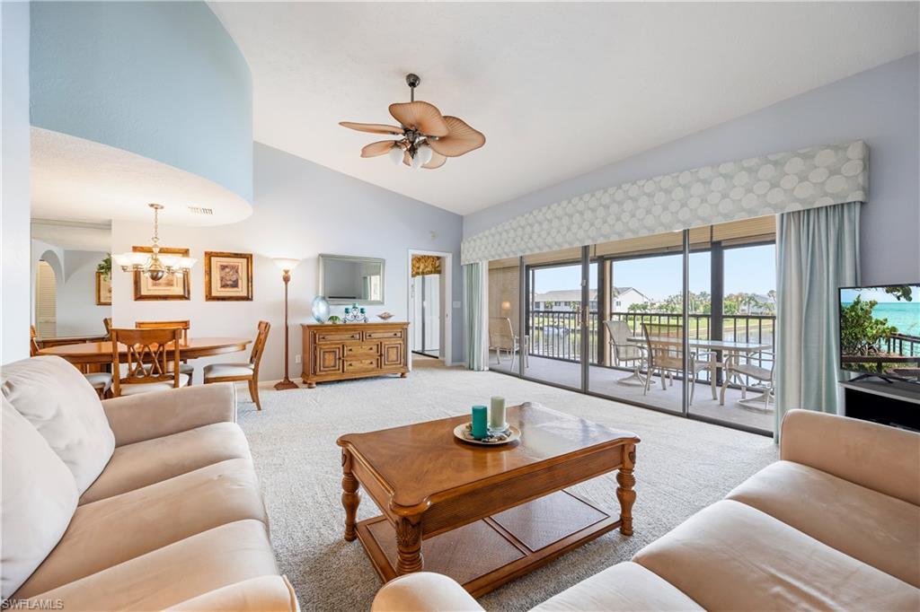 Image 4: Spacious living area featuring vaulted ceilings and light-colored carpeting