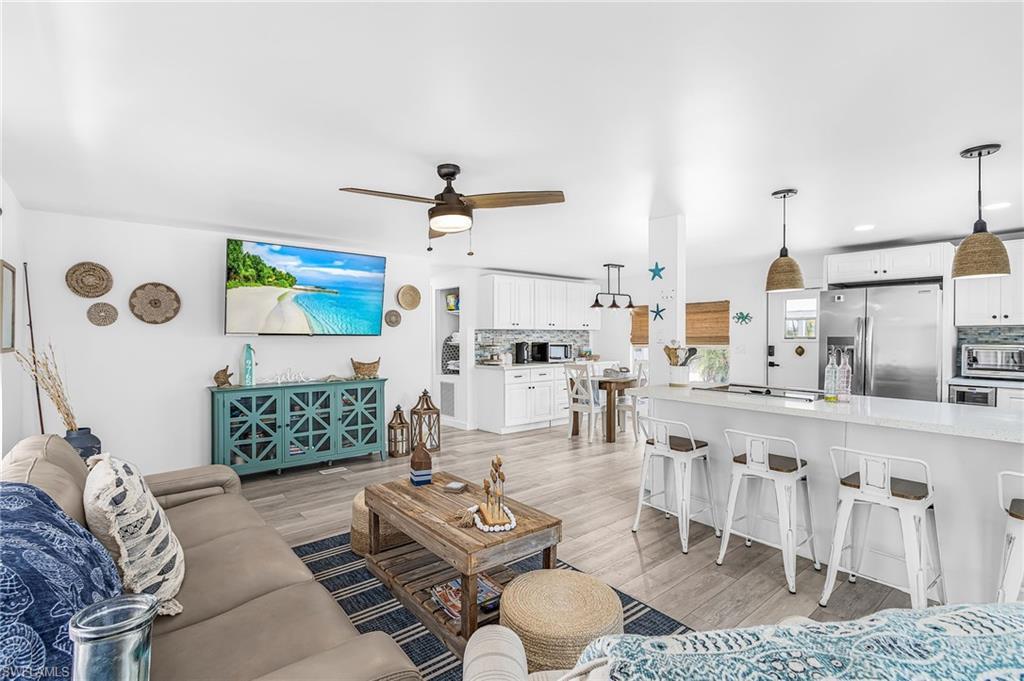 Image 4: Open concept living area featuring wood-finish flooring, a ceiling fan, and recessed lighting
