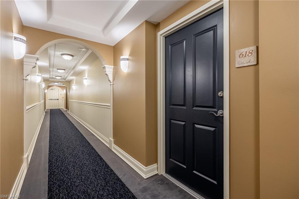 Image 3: Hall featuring a raised ceiling, dark carpet, and ornate columns