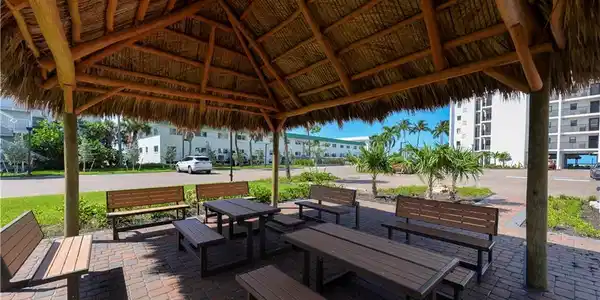 Image 4: Exterior Community Front of Building Tiki Patio with grill area adjaccent