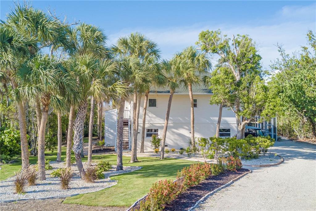 Image 2: NEW landscaping, NEW Impact windows, NEW stairs up to the 2nd level, plenty of space in the driveway to park and golf cart! 2+car garage, screened-in pool and patio area, bonus lower level, and so much more!