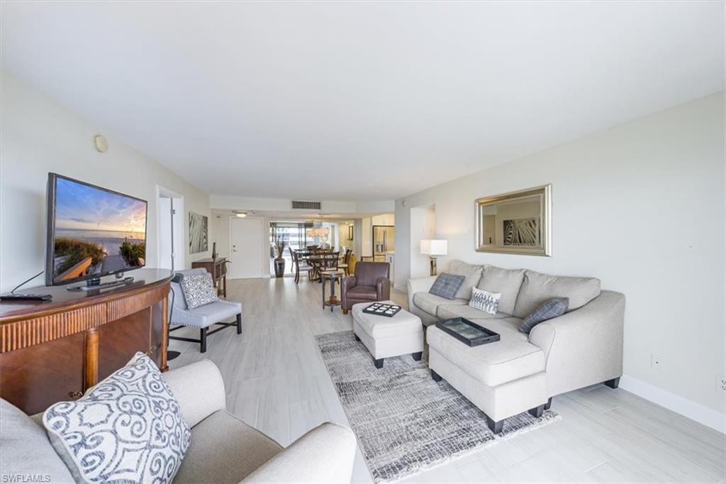 Image 4: Living area with light wood-style floors and baseboards