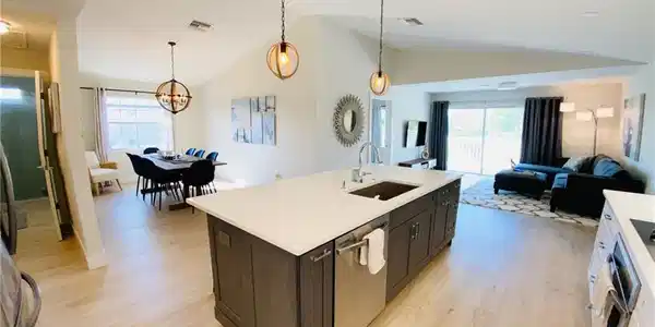 Image 4: Kitchen with hanging light fixtures, open floor plan, healthy amount of natural light, light wood-style flooring, and high vaulted ceiling