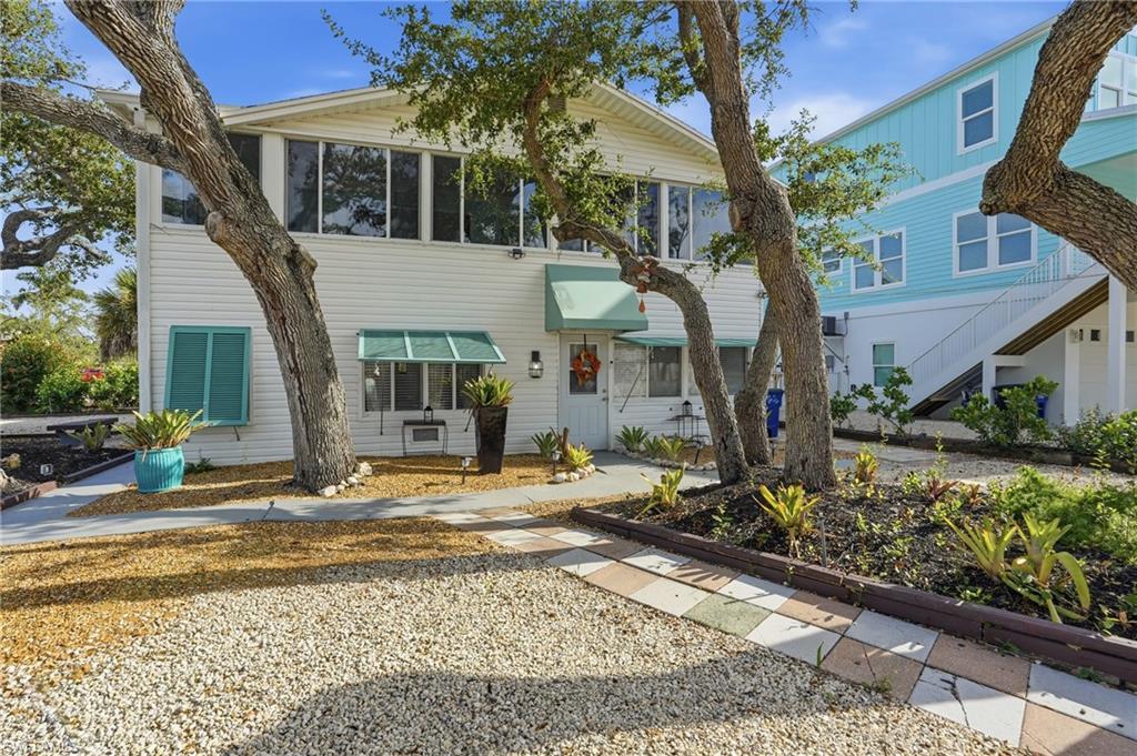 Image 1: View of front facade featuring stairway, a sunroom, and an attached garage - Virtually Edited Image