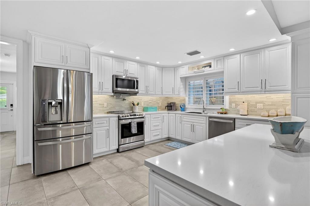 Image 4: Kitchen featuring stainless steel appliances, white cabinetry, healthy amount of natural light, and recessed lighting