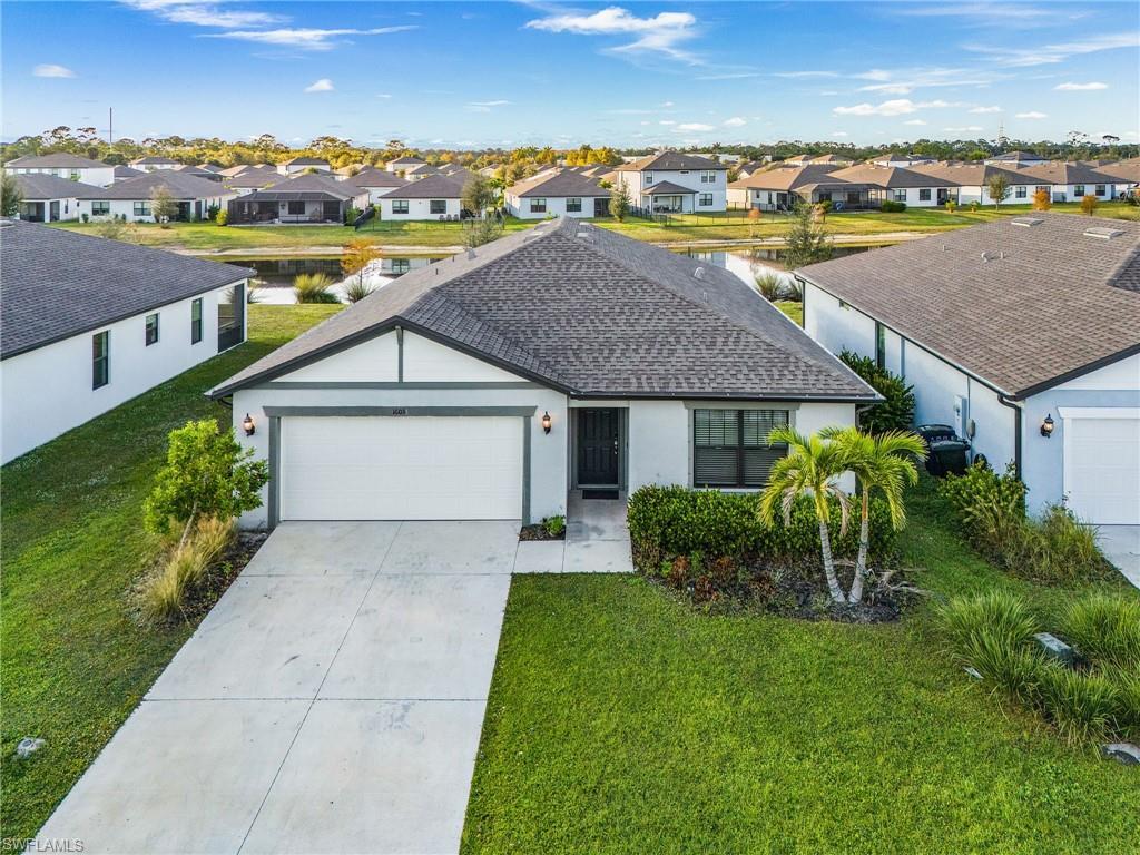 Image 1: Single story home featuring a front lawn, a residential view, an attached garage, and driveway