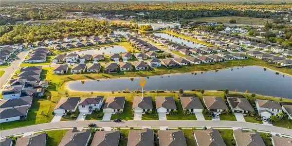 Image 2: Aerial overview of property's location featuring nearby suburban area and a nearby body of water