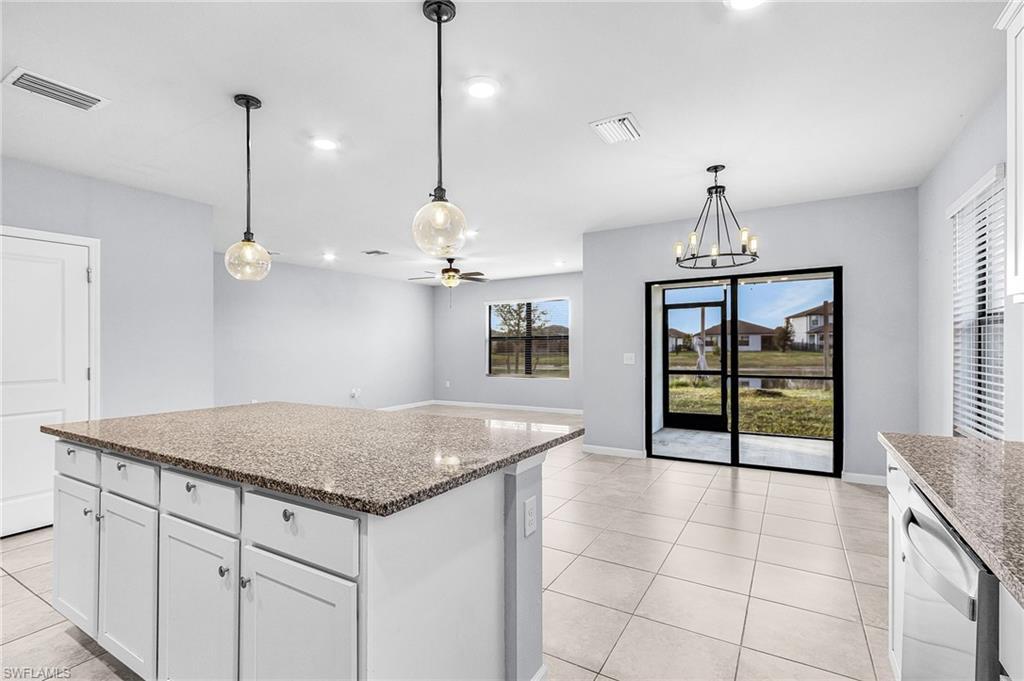 Image 4: Kitchen featuring white cabinetry, light fixtures, granite countertops, a kitchen island, and recessed lighting