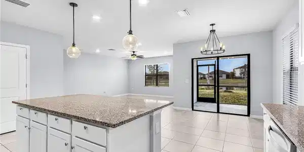Image 4: Kitchen featuring white cabinetry, light fixtures, granite countertops, a kitchen island, and recessed lighting