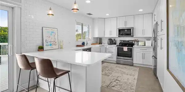 Image 3: Kitchen featuring a peninsula, stainless steel appliances, a breakfast bar, tasteful backsplash, and recessed lighting