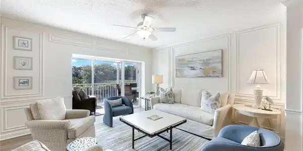 Image 3: Living area with a decorative wall, a ceiling fan, wood finished floors, and a textured ceiling