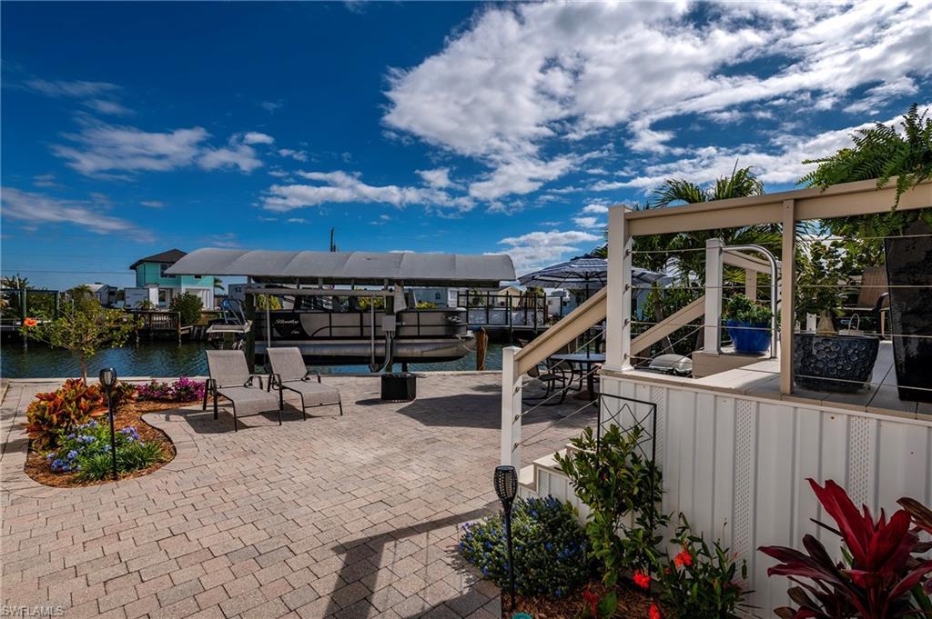 Image 1: View of patio / terrace with boat lift, a dock, and a water view