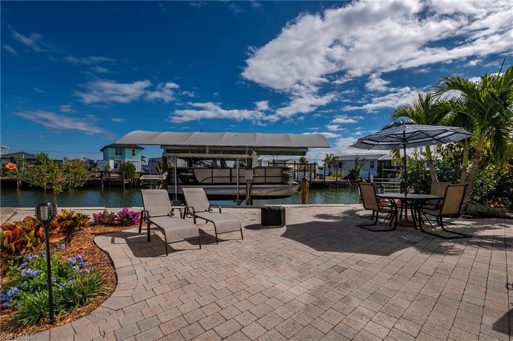 Image 2: View of patio featuring boat lift, a boat dock, and a water view