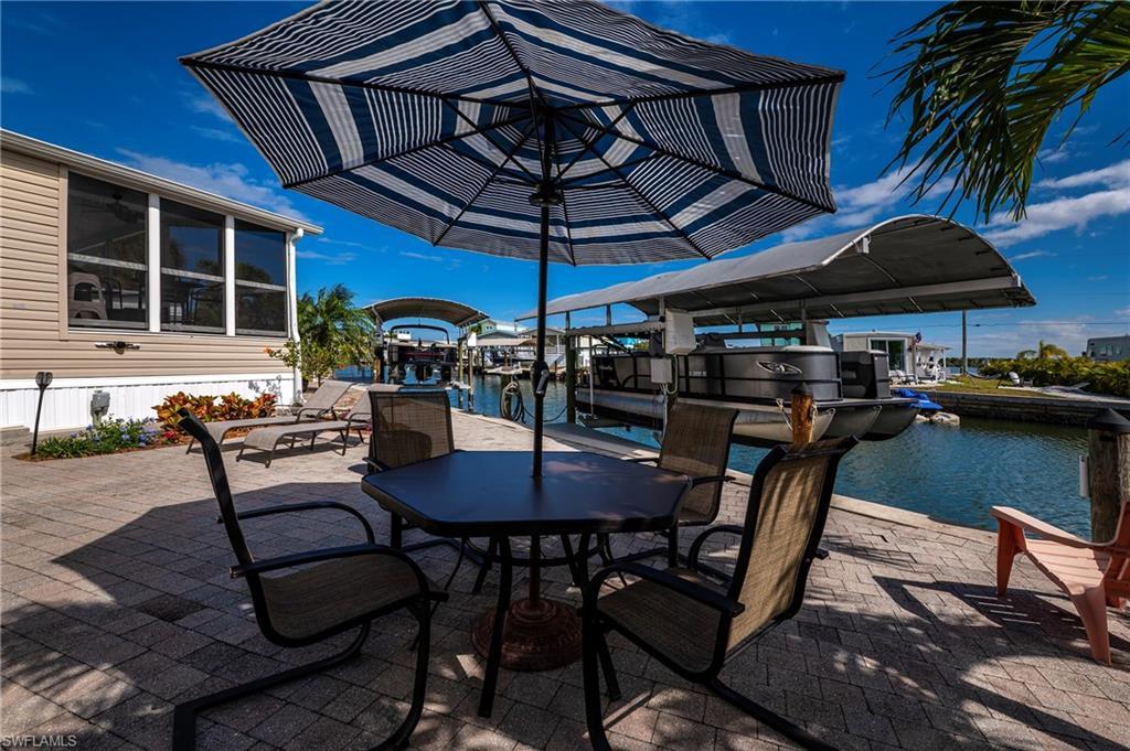 Image 4: View of patio with boat lift, a boat dock, and a water view