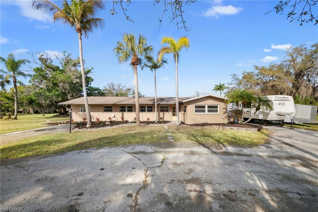 Image 1: Ranch-style house with a front lawn