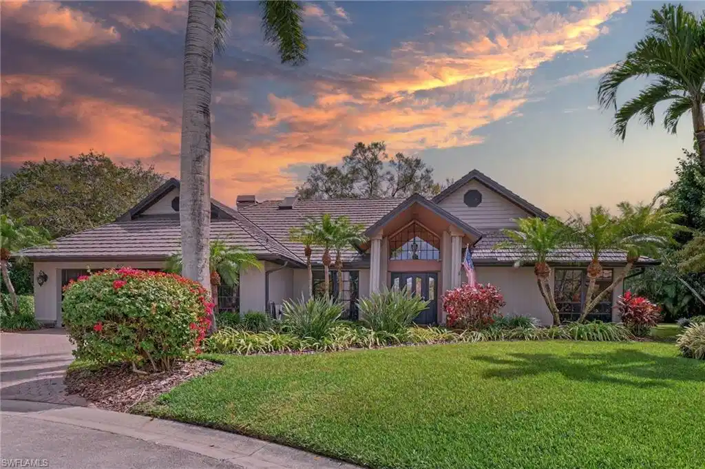 Image 1: View of front of property featuring a front yard, an attached garage, and driveway
