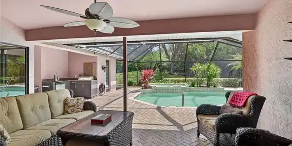 Image 3: Combined pool / hot tub featuring a sunroom, a patio, a lanai, and an outdoor kitchen and area to lounge