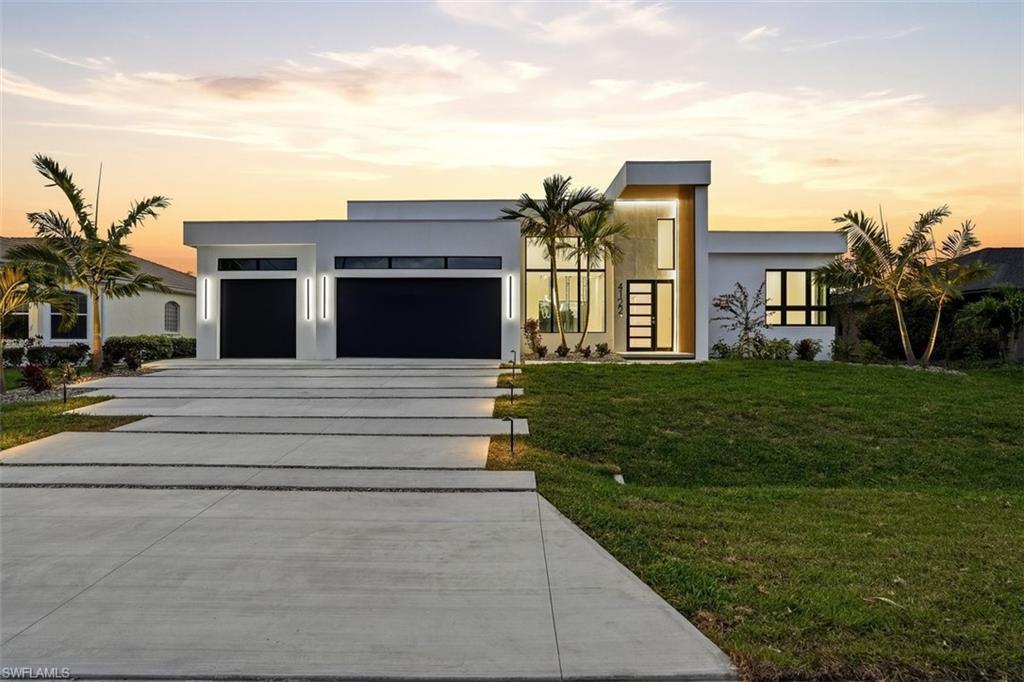 Image 1: Contemporary house with stucco siding, driveway, an attached garage, and a yard