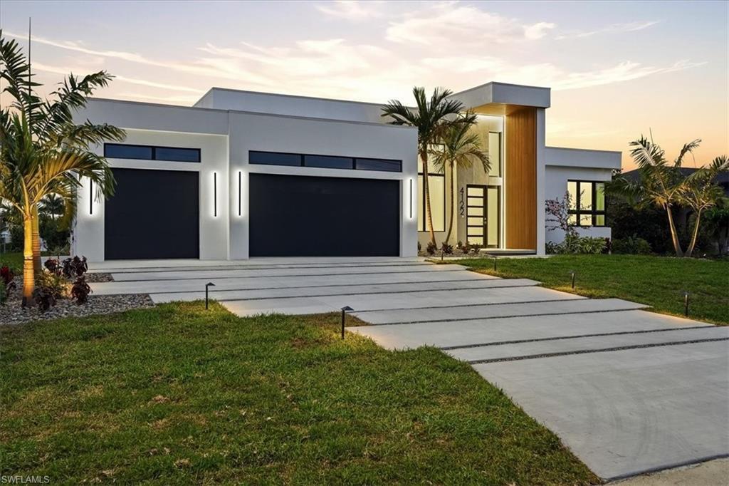 Image 2: Contemporary house featuring concrete driveway, an attached garage, stucco siding, and a front lawn