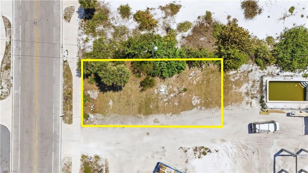 Image 3: Aerial view of property and surrounding area with property parcel outlinedchange color of water into natural dark blue canal water