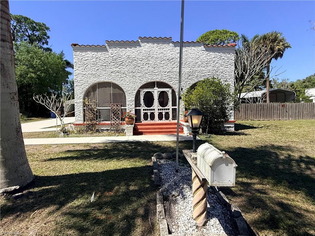 Image 2: Back of property with stucco siding and french doors