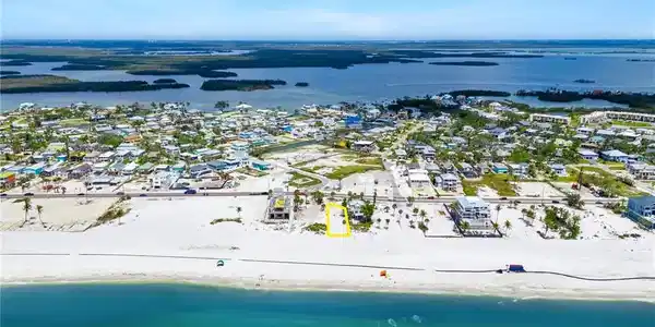 Image 4: Drone / aerial view with a water view, a beach view, and a residential view  - Virtually Edited Image