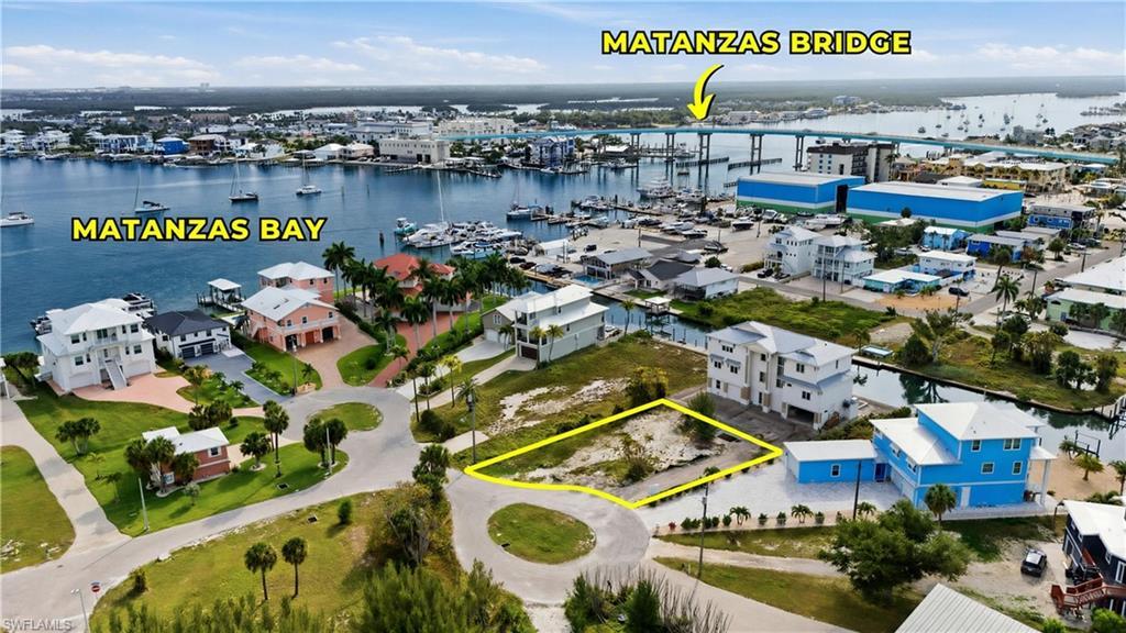 Image 1: Vacant land parcel situated on a paved street, featuring surrounding residential properties, proximity to a canal, and access to Matanzas Bay via waterways - Virtually Edited Image