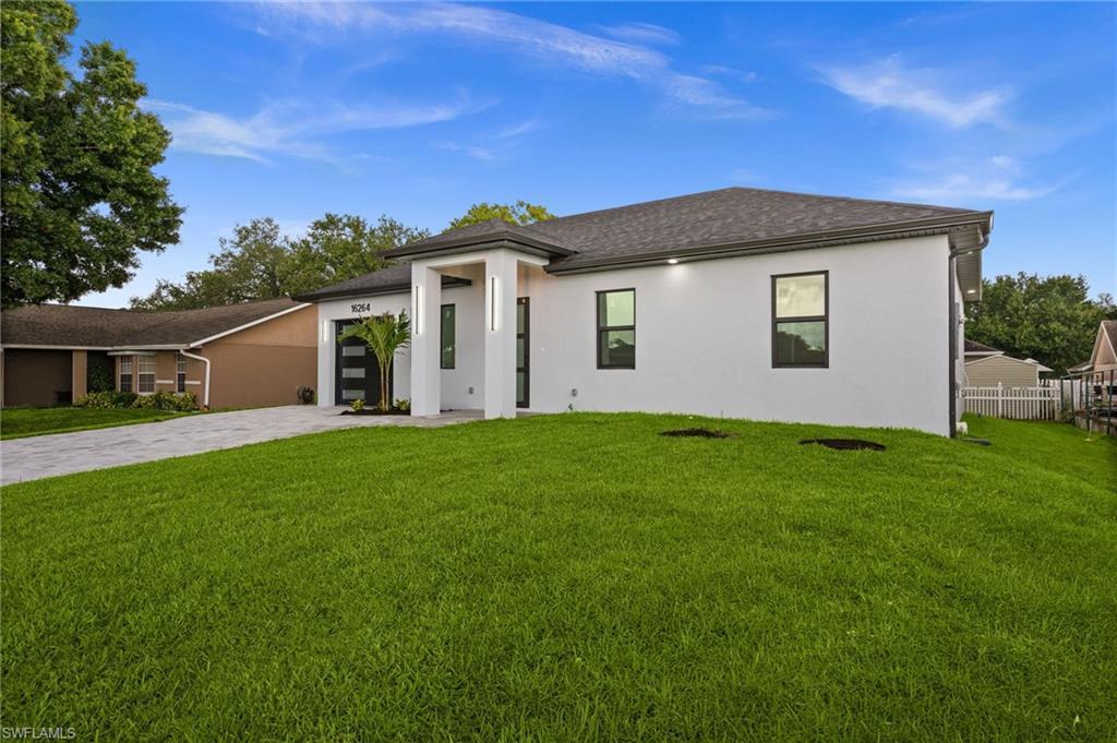 Image 2: Contemporary white stucco exterior with a dark shingle roof
