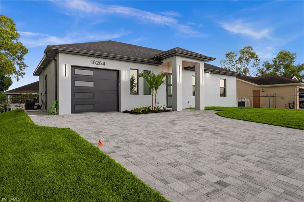 Image 3: Contemporary exterior featuring a paver driveway, an attached garage with translucent paneling, and an inviting covered entry